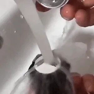 Rinsing the mini shaver head under running water